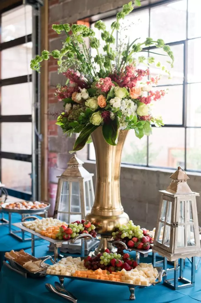 floral arrangement and fruit platter on table inside avenue d event space