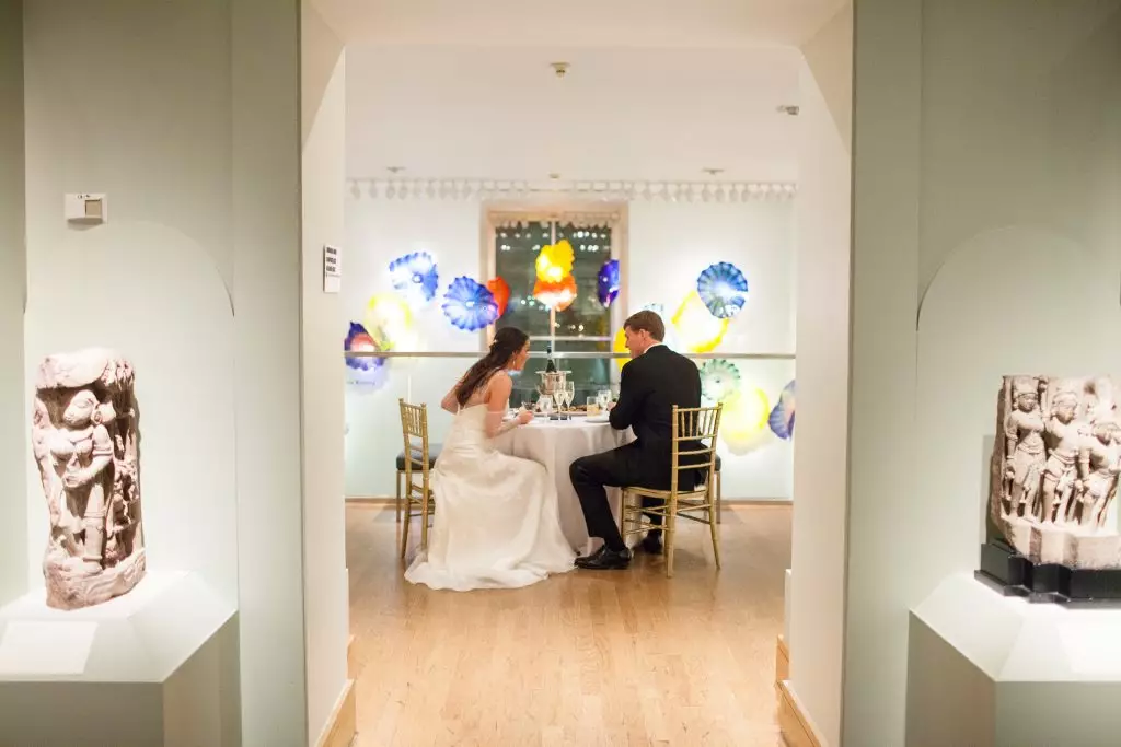 bride and groom have dinner at wedding table in birmingham museum of art