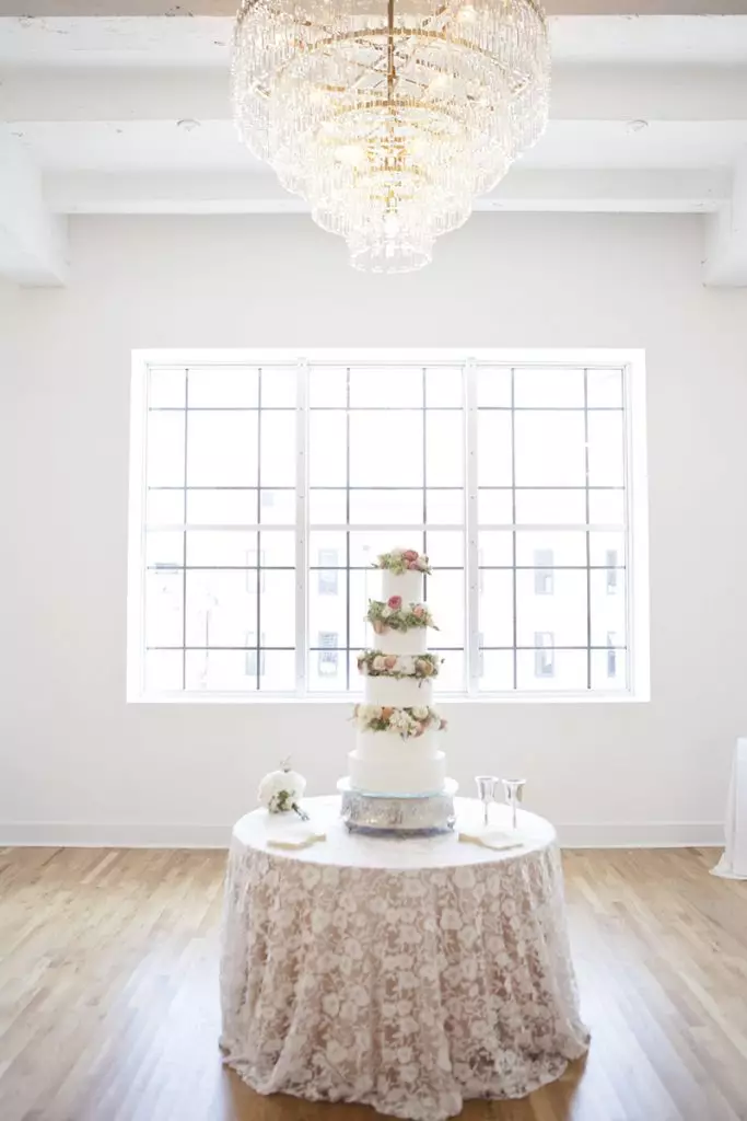 tiered wedding cake on table with natural light in kress building