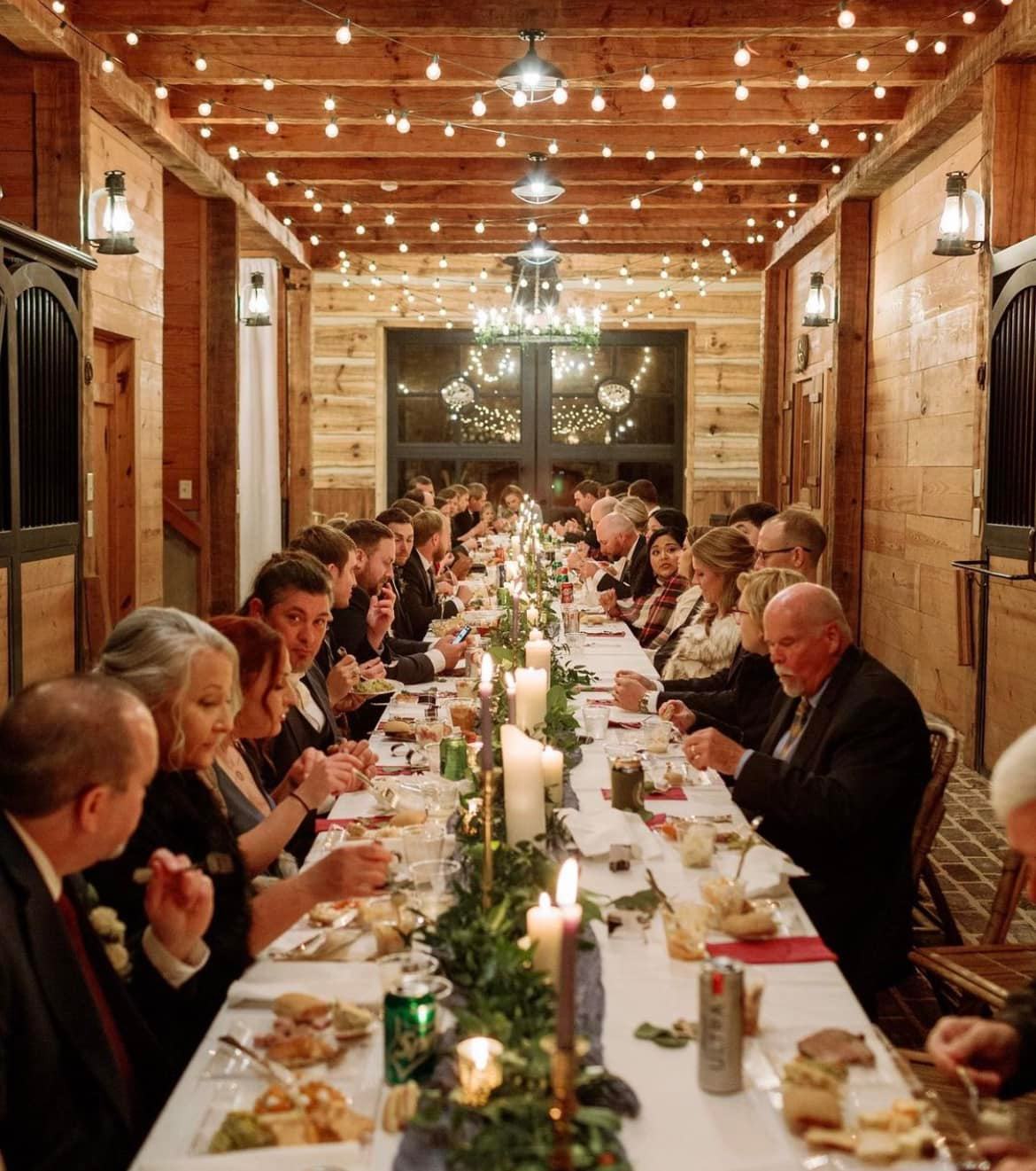 long table decorated for wedding guests dinner inside at swan lake stables