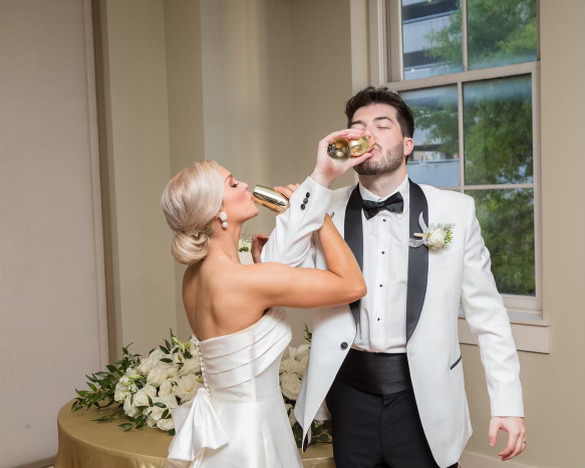 bride and groom chugging gold champagne flutes wedding day