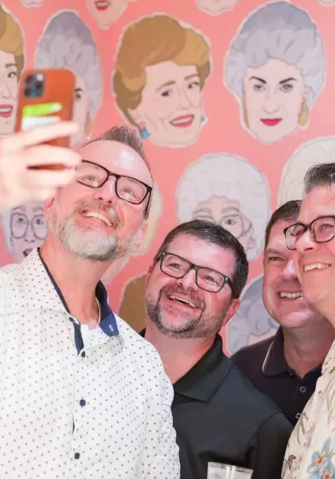 men posing in front of old lady wall at avenue d event space