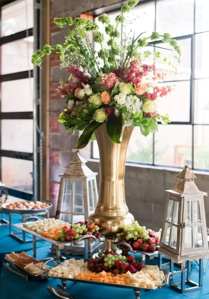 floral arrangement and fruit platter on table inside avenue d event space