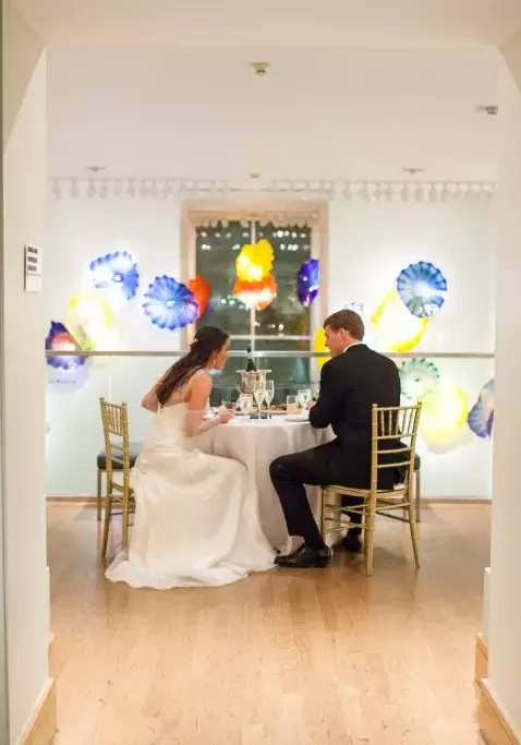 bride and groom have dinner at wedding table in birmingham museum of art