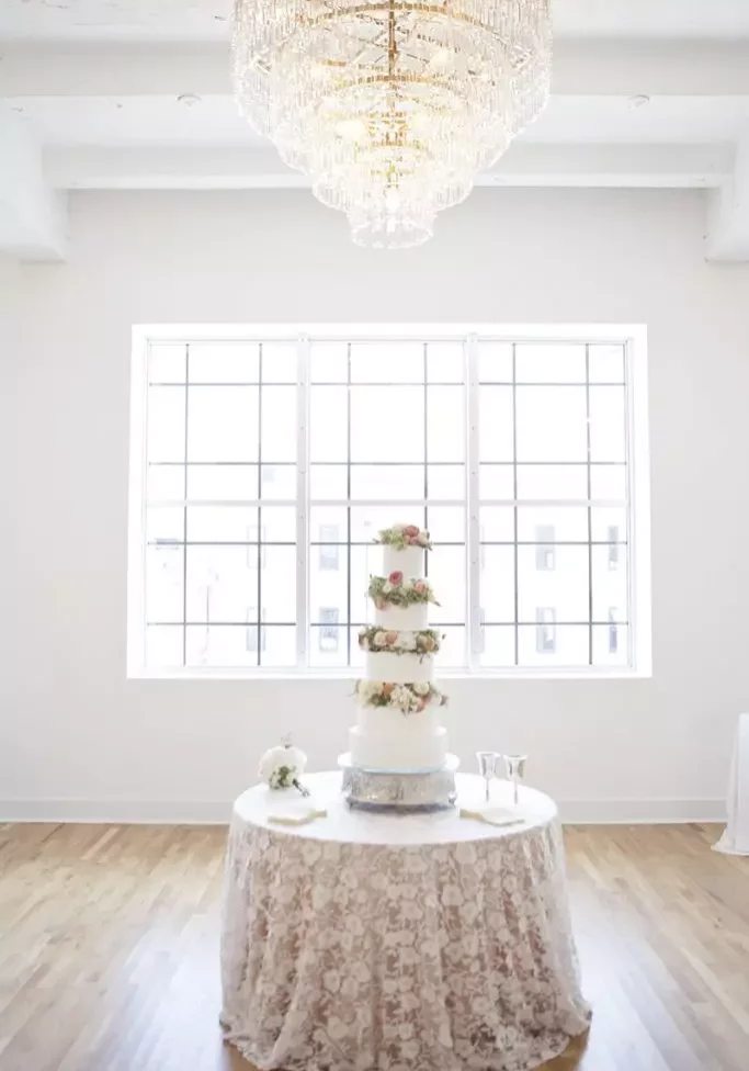 tiered wedding cake on table with natural light in kress building