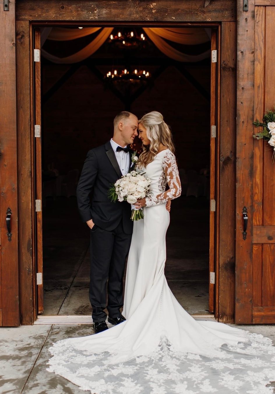 bride and groom posing wooden barn