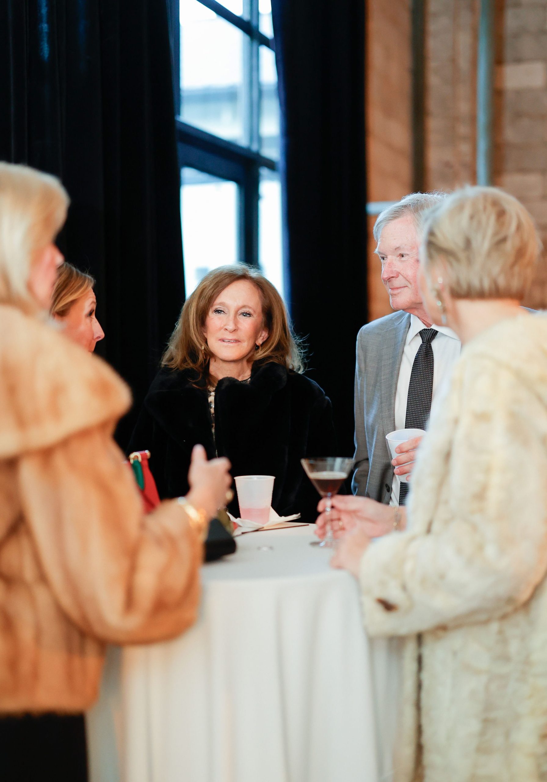 wedding guests talking inside southerly warehouse with alcohol